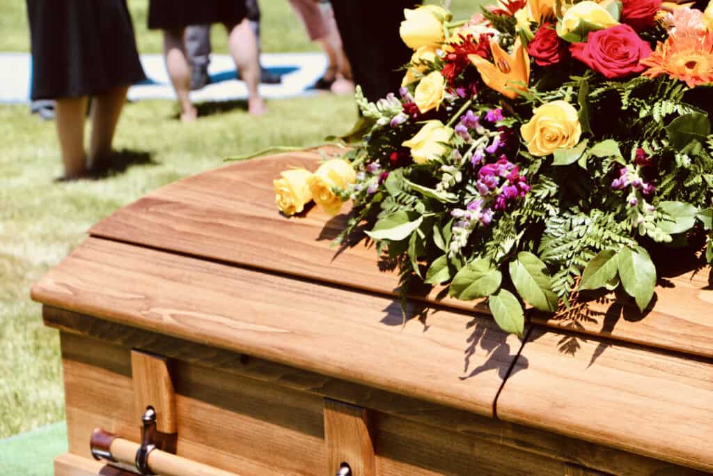 lovely-floral-arrangement-on-wood-casket-mourning-loss-of-loved-one-death-of-friend-or-family-member_t20_wkm0jK